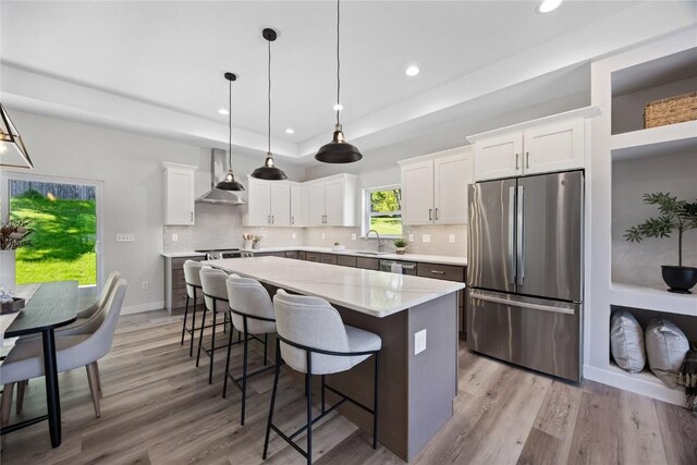 706 Silver Ln, Iowa City, IA 52245 - kitchen with appliances with stainless steel finishes, a raised ceiling, recessed lighting, wall chimney exhaust hood, and a sink