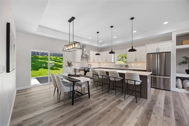 706 Silver Ln, Iowa City, IA 52245 - dining space with a tray ceiling, light wood finished floors, recessed lighting, and baseboards