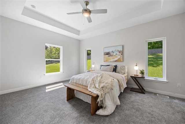 706 Silver Ln, Iowa City, IA 52245 - carpeted bedroom with a tray ceiling, baseboards, and ceiling fan