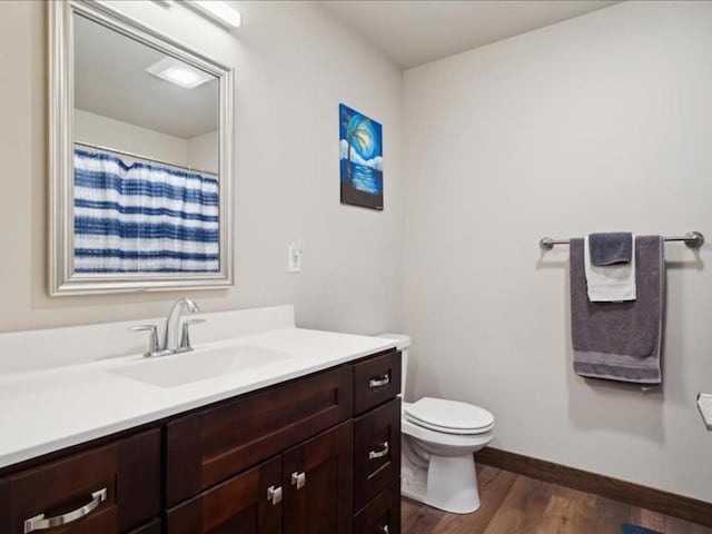 902 Creekside Dr, Tiffin, IA 52340 - bathroom with vanity, wood finished floors, toilet, and baseboards