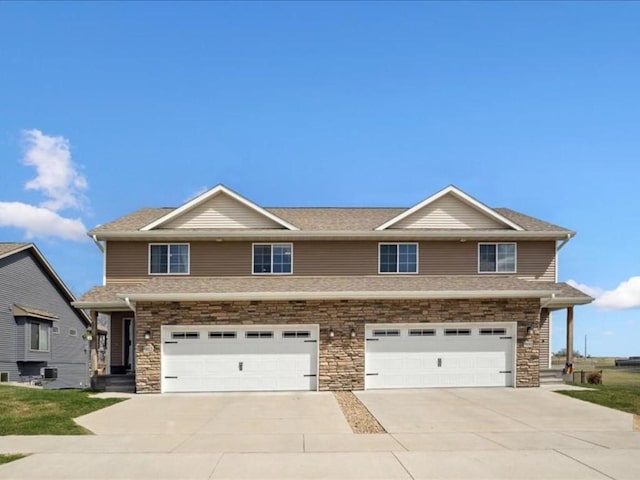 902 Creekside Dr, Tiffin, IA 52340 - view of front of house with a garage, concrete driveway, and stone siding