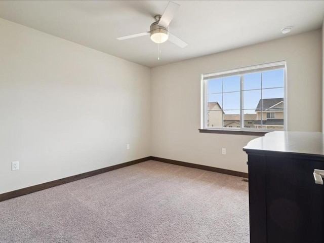 902 Creekside Dr, Tiffin, IA 52340 - spare room featuring light colored carpet, baseboards, and a ceiling fan