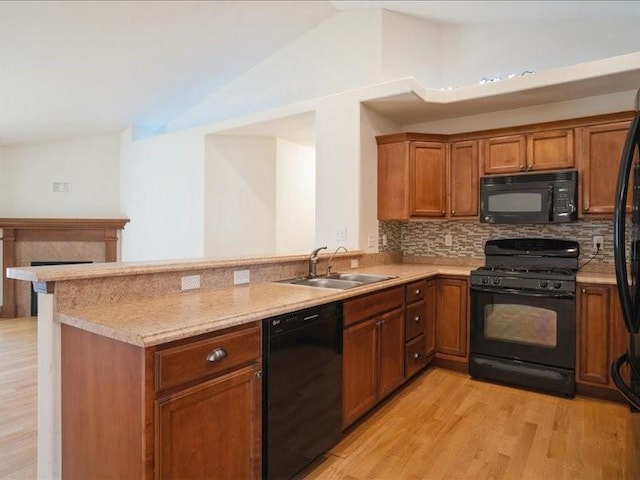 3314 35th Ave, Marion, IA 52302 - kitchen featuring black appliances, a sink, light wood-style flooring, tasteful backsplash, and lofted ceiling