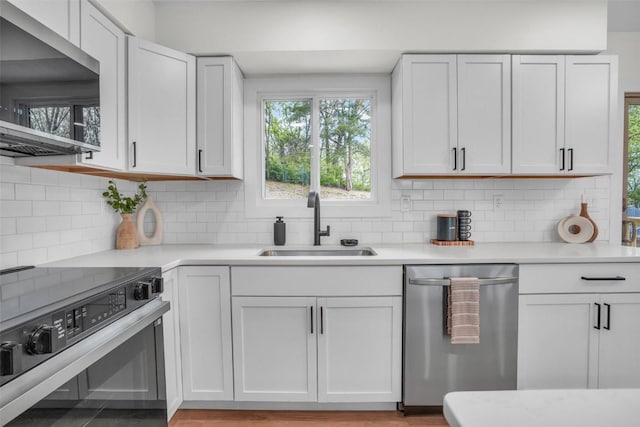 1418 26th St NW, Cedar Rapids, IA 52405 - kitchen featuring appliances with stainless steel finishes, a sink, light countertops, white cabinetry, and tasteful backsplash