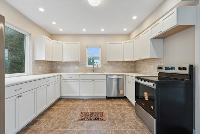 306 7th Ave, Clarence, IA 52216 - kitchen with stainless steel appliances, a sink, decorative backsplash, recessed lighting, and light countertops