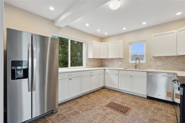 306 7th Ave, Clarence, IA 52216 - kitchen with stainless steel appliances, a sink, backsplash, white cabinetry, and light countertops