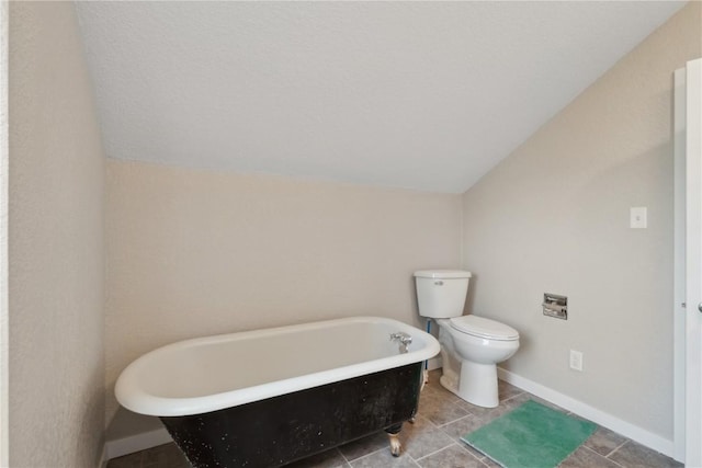 306 7th Ave, Clarence, IA 52216 - full bathroom with a freestanding tub, lofted ceiling, toilet, baseboards, and tile patterned flooring