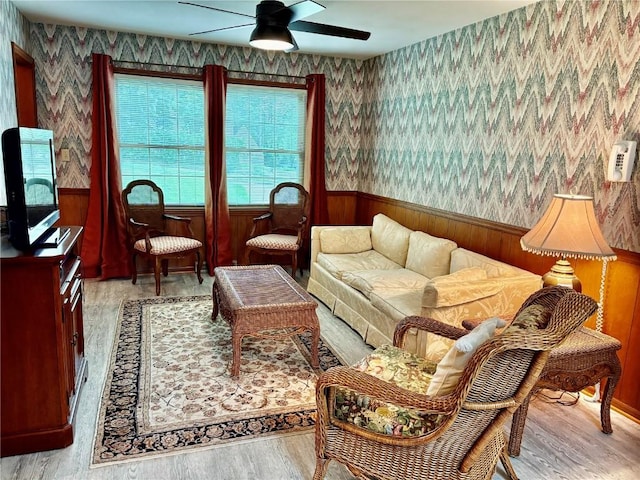 832 17th St SE, Cedar Rapids, IA 52403 - living area with a wainscoted wall, ceiling fan, wood finished floors, wallpapered walls, and wooden walls