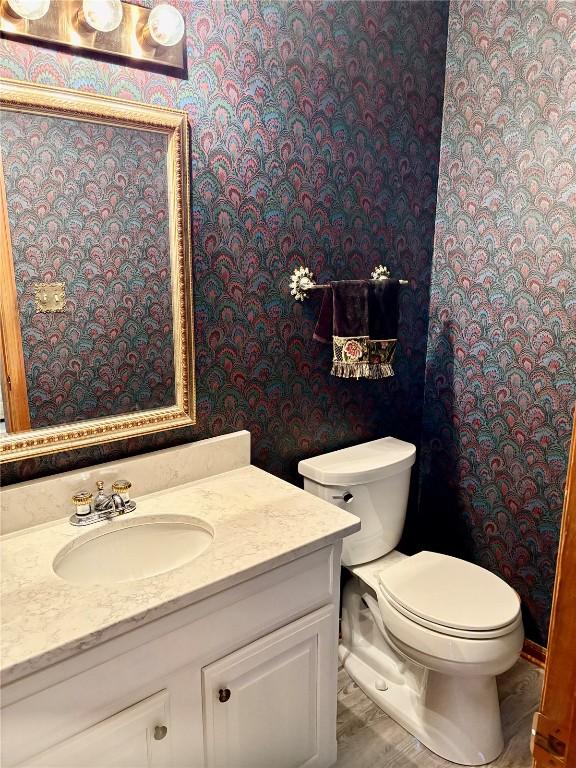 832 17th St SE, Cedar Rapids, IA 52403 - bathroom featuring wallpapered walls, vanity, and toilet