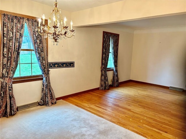 832 17th St SE, Cedar Rapids, IA 52403 - unfurnished room featuring a chandelier, baseboards, and wood finished floors
