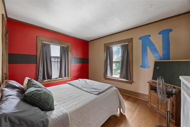 540 E 4th St, Tipton, IA 52772 - bedroom featuring wood finished floors, multiple windows, baseboards, and crown molding