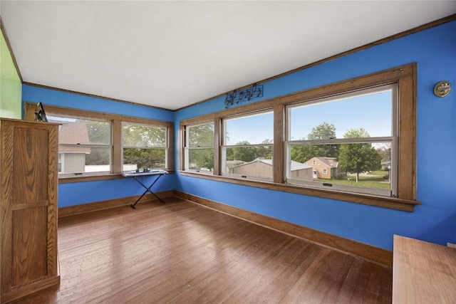 540 E 4th St, Tipton, IA 52772 - unfurnished room featuring healthy amount of natural light, baseboards, wood finished floors, and ornamental molding