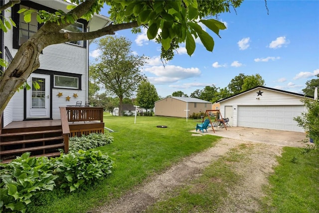 540 E 4th St, Tipton, IA 52772 - view of grassy yard featuring a deck, an outbuilding, and a detached garage