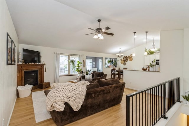 2806 Dawn Ave SW, Cedar Rapids, IA 52404 - living area featuring lofted ceiling, light wood-style floors, a ceiling fan, and a glass covered fireplace