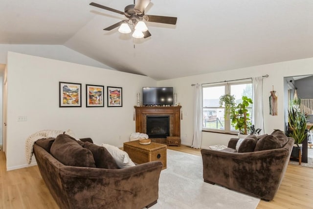 2806 Dawn Ave SW, Cedar Rapids, IA 52404 - living area with lofted ceiling, light wood-style floors, a glass covered fireplace, and ceiling fan