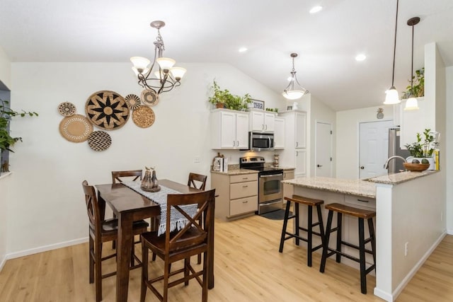 2806 Dawn Ave SW, Cedar Rapids, IA 52404 - dining area with light wood finished floors, lofted ceiling, recessed lighting, and a chandelier
