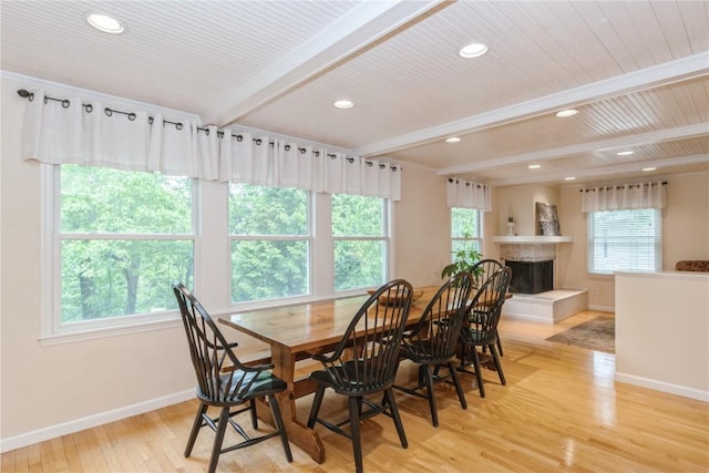 2232 Birchwood Dr NE, Cedar Rapids, IA 52402 - dining space with baseboards, beamed ceiling, healthy amount of natural light, light wood-style floors, and a fireplace with raised hearth