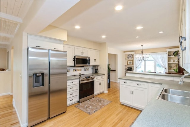 2232 Birchwood Dr NE, Cedar Rapids, IA 52402 - kitchen with appliances with stainless steel finishes, a sink, white cabinets, light wood-style floors, and tasteful backsplash