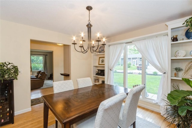 2232 Birchwood Dr NE, Cedar Rapids, IA 52402 - dining space with a chandelier, light wood-style floors, wine cooler, and baseboards