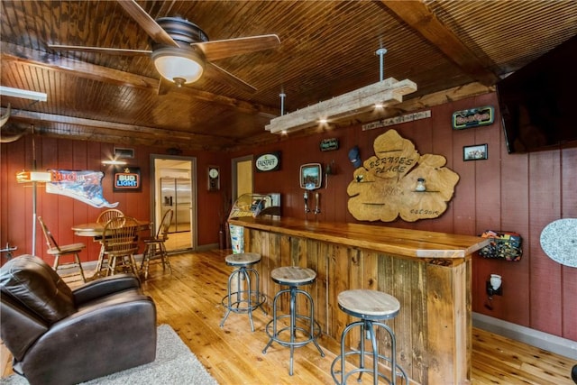 2232 Birchwood Dr NE, Cedar Rapids, IA 52402 - indoor dry bar with wooden ceiling with exposed beams, wood-type flooring, wooden walls, ceiling fan, and stainless steel built in fridge