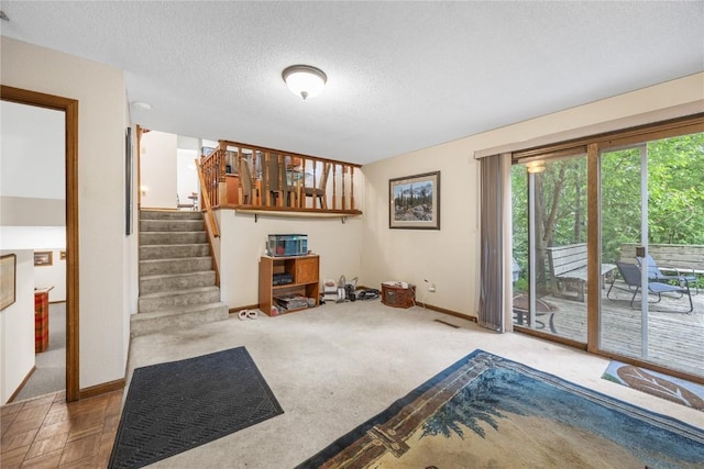 2623 Iris Ave NW, Cedar Rapids, IA 52405 - carpeted living room with stairs, baseboards, and a textured ceiling
