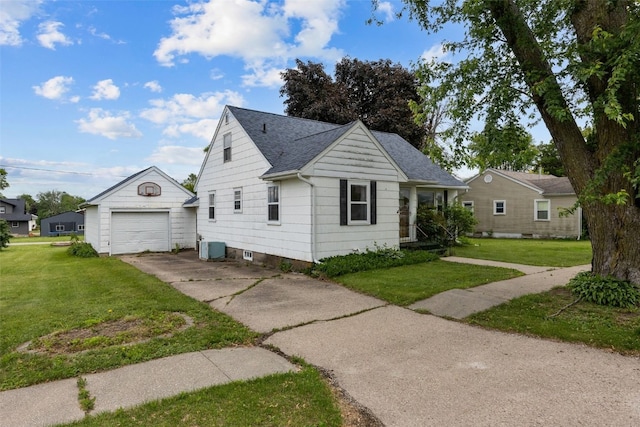 307 2nd Ave, Clarence, IA 52216 - view of front of property featuring an outbuilding, concrete driveway, a front lawn, a shingled roof, and central AC