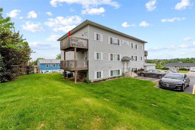 3107 Johnson Ave NW Unit 4, Cedar Rapids, IA 52405 - rear view of property featuring uncovered parking, a lawn, a balcony, and central AC