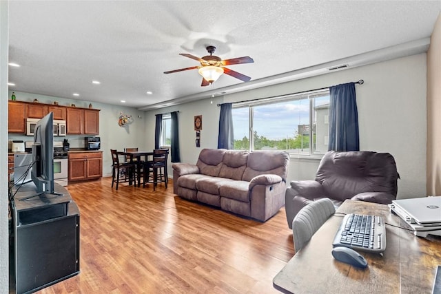 3107 Johnson Ave NW Unit 4, Cedar Rapids, IA 52405 - living room with a ceiling fan, light wood-style flooring, recessed lighting, and a textured ceiling
