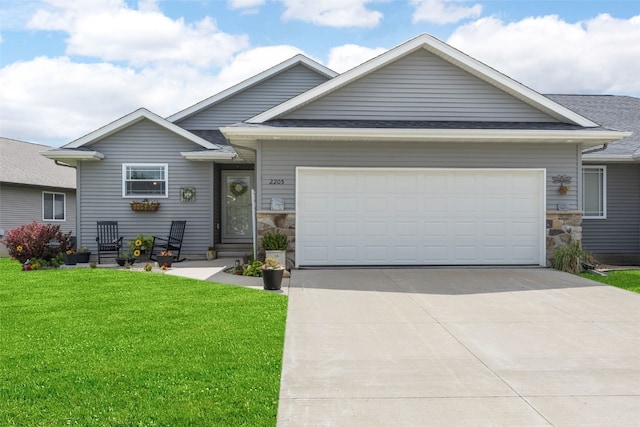 2205 Snapdragon Cir SW, Cedar Rapids, IA 52404 - view of front of property featuring stone siding, an attached garage, concrete driveway, and a front lawn