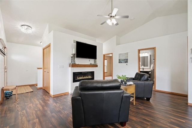 1562 Hunters Creek Way, Marion, IA 52302 - living area featuring vaulted ceiling, a ceiling fan, a glass covered fireplace, and dark wood-style flooring