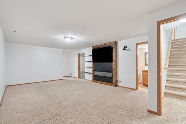 1562 Hunters Creek Way, Marion, IA 52302 - empty room featuring light colored carpet, stairs, and a textured ceiling