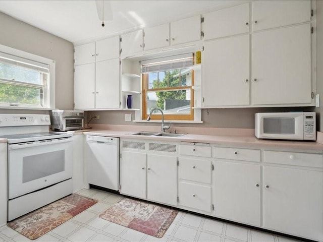 1813 3rd Ave SE, Cedar Rapids, IA 52403 - kitchen featuring white appliances, a sink, light flooring, light countertops, and white cabinets