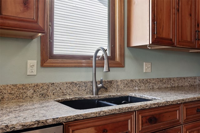 1724 Hamer Dr NW, Cedar Rapids, IA 52405 - kitchen featuring a sink, brown cabinets, and light stone countertops