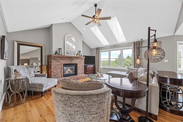1355 Red Star Rd, Tipton, IA 52772 - living area featuring a fireplace, a ceiling fan, light wood-type flooring, a skylight, and high vaulted ceiling