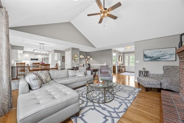 1355 Red Star Rd, Tipton, IA 52772 - living area featuring ceiling fan, wood finished floors, high vaulted ceiling, and a chandelier