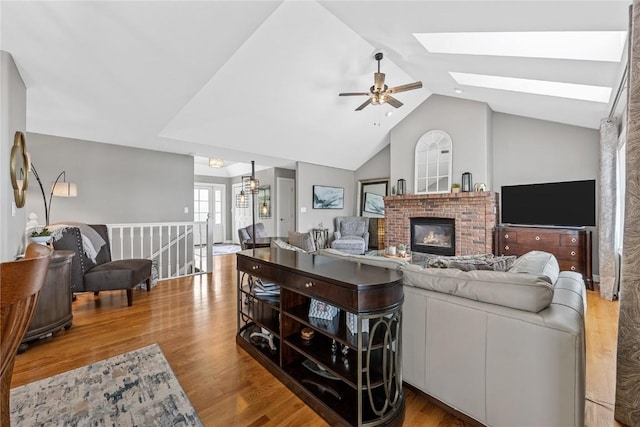 1355 Red Star Rd, Tipton, IA 52772 - living room with ceiling fan, lofted ceiling, wood finished floors, a skylight, and a brick fireplace