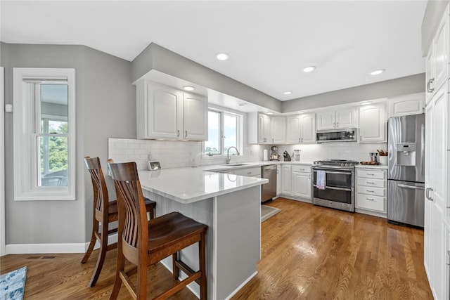 1355 Red Star Rd, Tipton, IA 52772 - kitchen featuring stainless steel appliances, a peninsula, a kitchen breakfast bar, a sink, and white cabinetry
