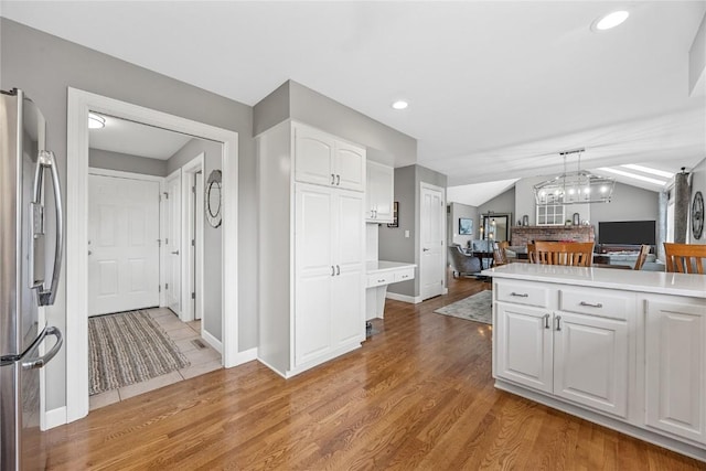 1355 Red Star Rd, Tipton, IA 52772 - kitchen featuring freestanding refrigerator, open floor plan, white cabinets, light countertops, and wood finished floors