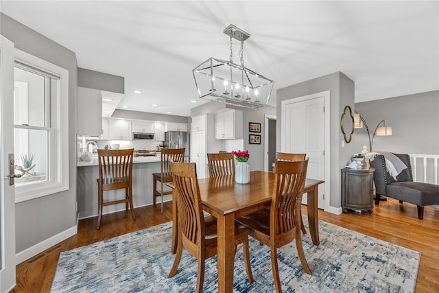 1355 Red Star Rd, Tipton, IA 52772 - dining room featuring a chandelier, light wood-style floors, and baseboards