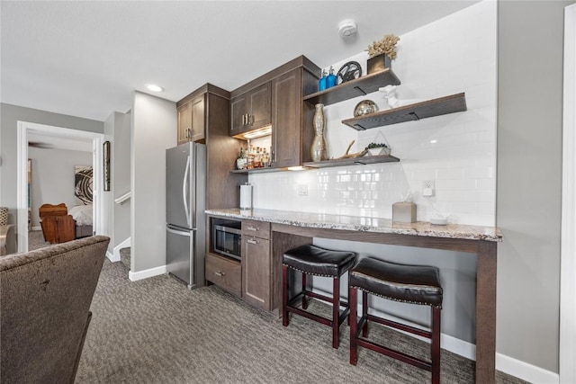1355 Red Star Rd, Tipton, IA 52772 - kitchen with appliances with stainless steel finishes, open shelves, carpet, decorative backsplash, and light stone counters