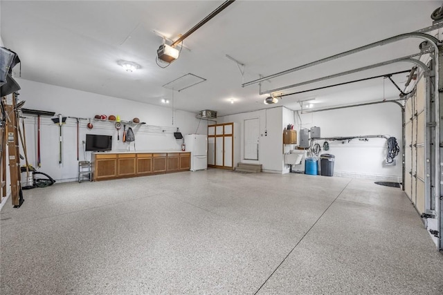 1355 Red Star Rd, Tipton, IA 52772 - garage with freestanding refrigerator, a garage door opener, and a sink
