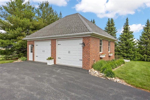 1355 Red Star Rd, Tipton, IA 52772 - view of home's exterior with roof with shingles, brick siding, a garage, and a yard