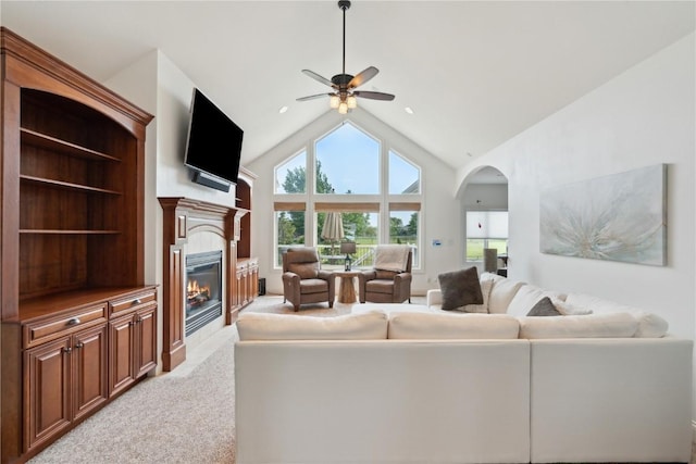 1485 Huntington Hills Dr, Marion, IA 52302 - living area featuring a ceiling fan, a glass covered fireplace, light carpet, arched walkways, and high vaulted ceiling