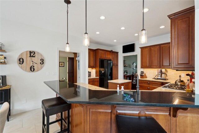 1485 Huntington Hills Dr, Marion, IA 52302 - kitchen with black fridge, tasteful backsplash, light tile patterned flooring, stainless steel gas stovetop, and a peninsula