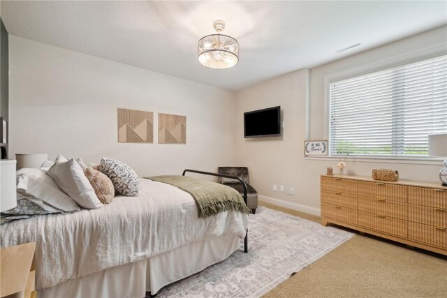 1485 Huntington Hills Dr, Marion, IA 52302 - bedroom with light carpet, baseboards, and a chandelier