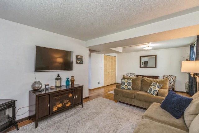 5817 Underwood SW, Cedar Rapids, IA 52404 - living room with wood finished floors, a wood stove, a textured ceiling, and baseboards