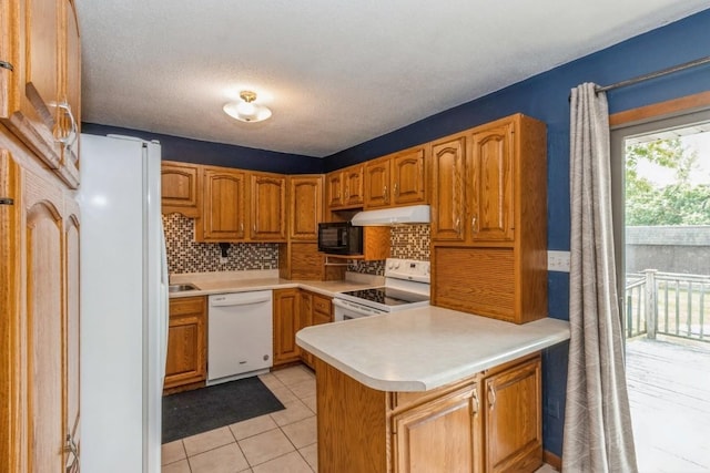 5817 Underwood SW, Cedar Rapids, IA 52404 - kitchen featuring white appliances, a peninsula, backsplash, under cabinet range hood, and light countertops