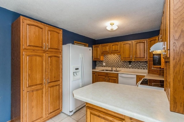 5817 Underwood SW, Cedar Rapids, IA 52404 - kitchen featuring white appliances, a sink, light countertops, a peninsula, and under cabinet range hood