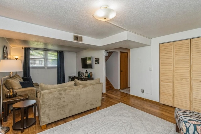 5817 Underwood SW, Cedar Rapids, IA 52404 - living room featuring a textured ceiling, wood finished floors, stairs, and baseboards