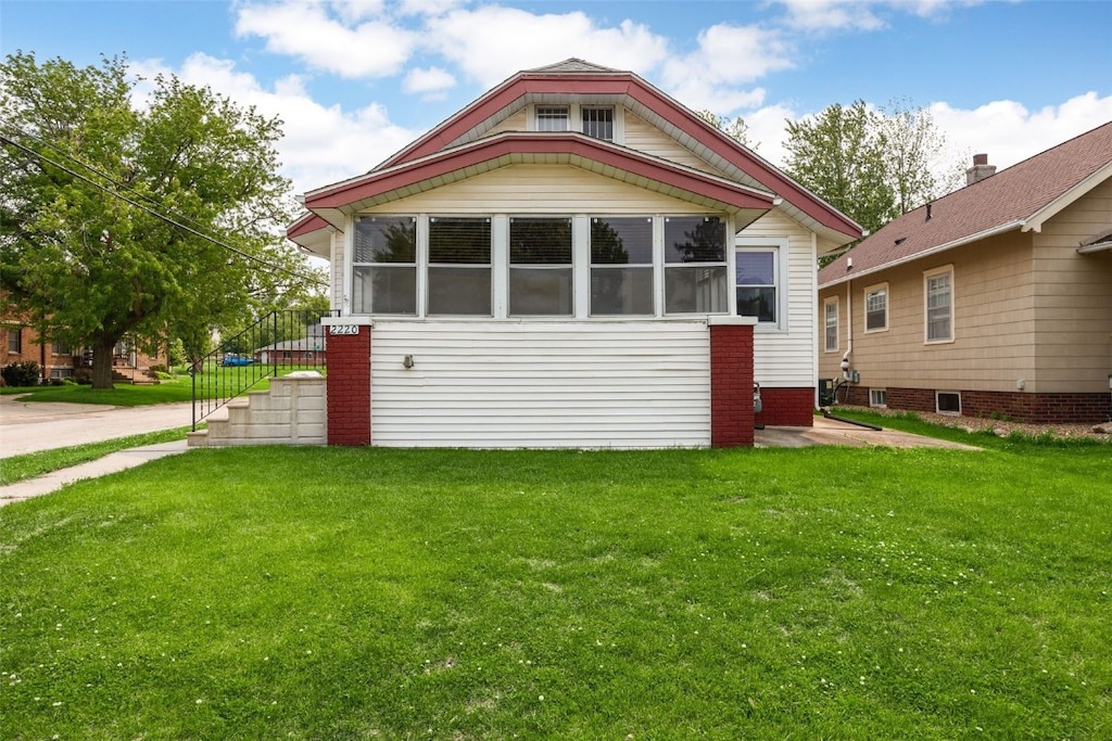 2220 D St SW, Cedar Rapids, IA 52404 - view of front of property featuring a front yard and a sunroom